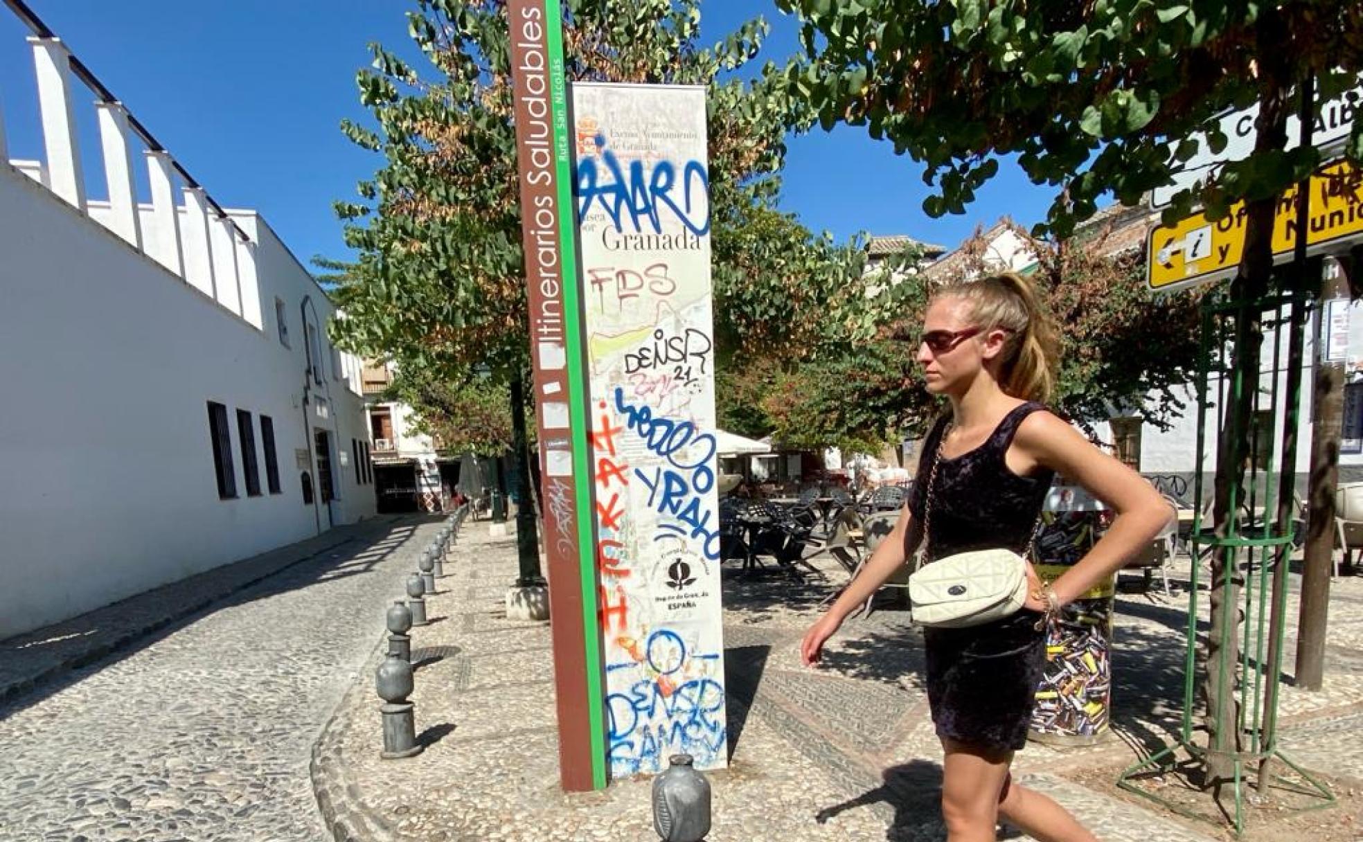 Turista intentando consultar un cartel ubicado en la Plaza Aliatar del Albaicín