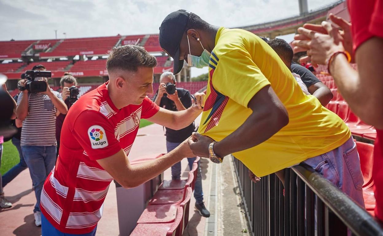 Santiago Arias firma una camiseta de Colombia a un compatriota en su presentación. 