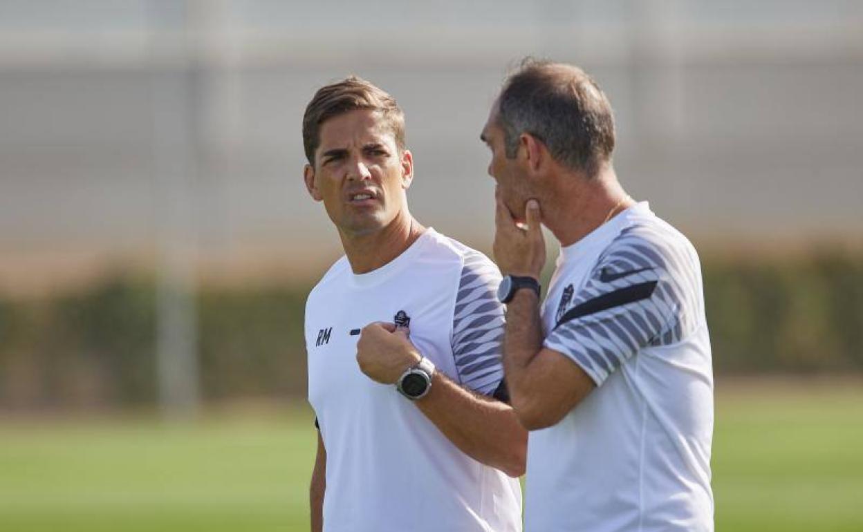 Robert Moreno, entrenador del Granada, charla con su prepador físico. 