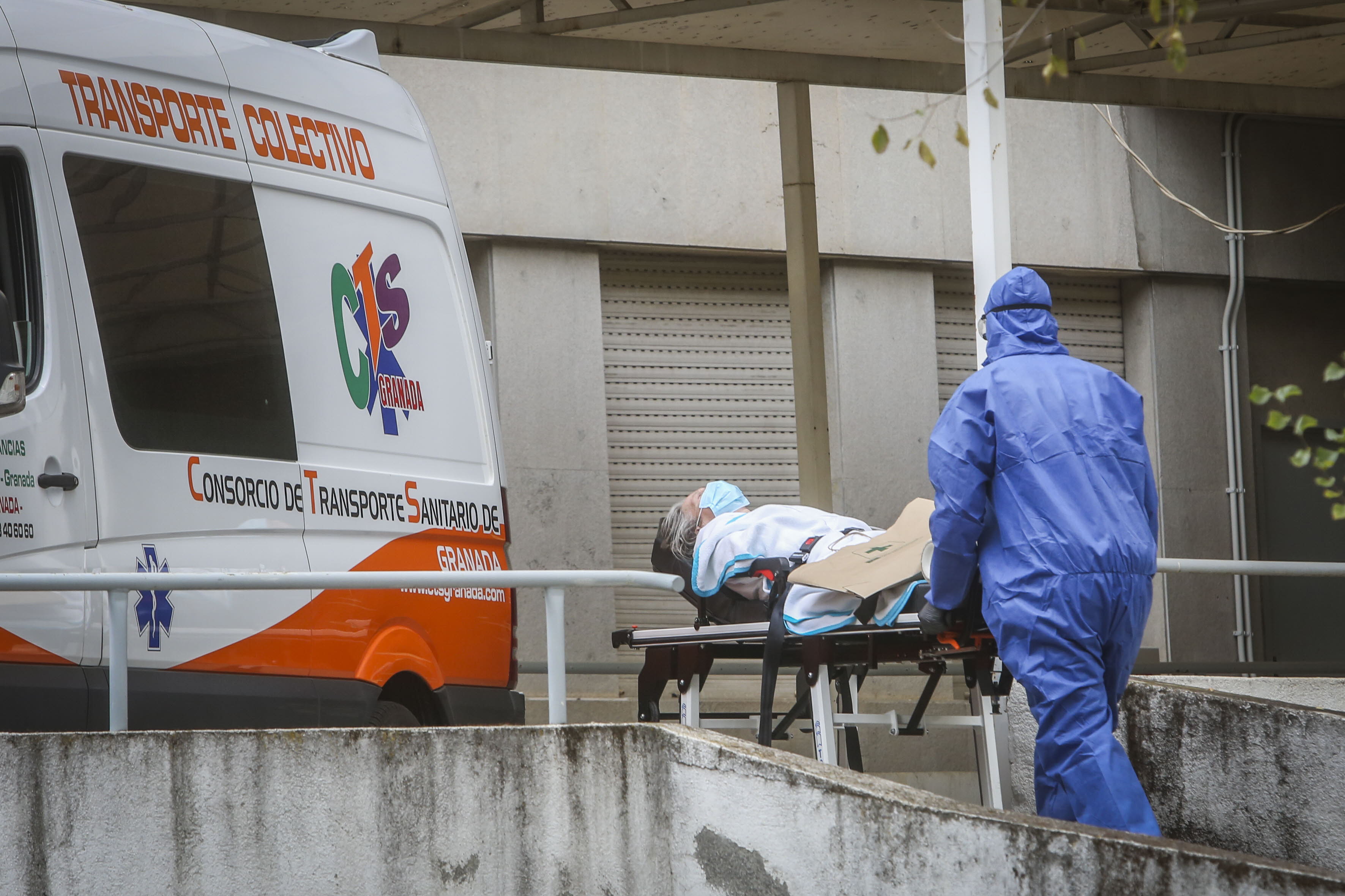 Un sanitario traslada a una paciente a una ambulancia en Granada.