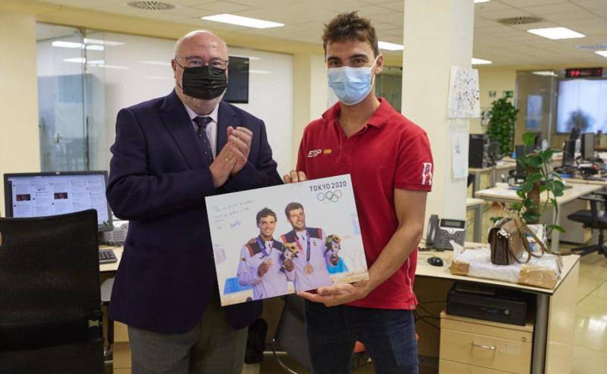 Jordi Xammar muestra su obsequio, dedicado, ante el aplauso del director de IDEAL, Eduardo Peralta. 