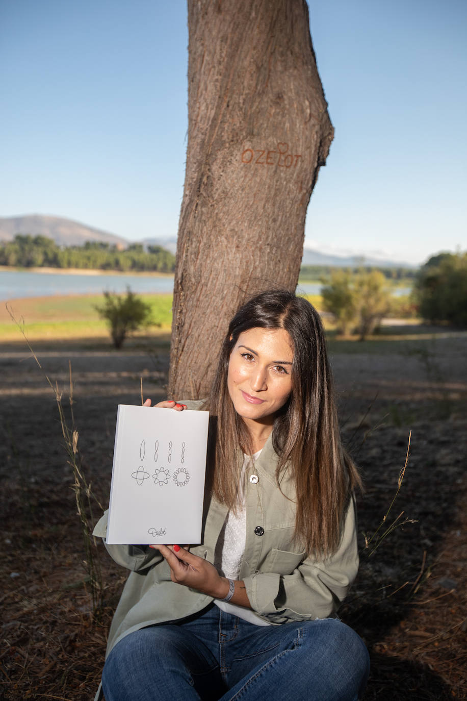 Patricia Valero muestra orgullosa el libro en honor a su hermano en el Pantano de Cubillas. 