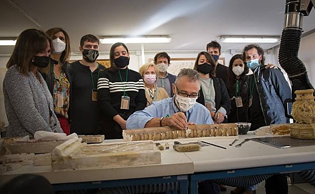 Finalistas del Premio Cervezas Alhambra de Arte Emergente observan al maestro yesero Ramón Rubio. 
