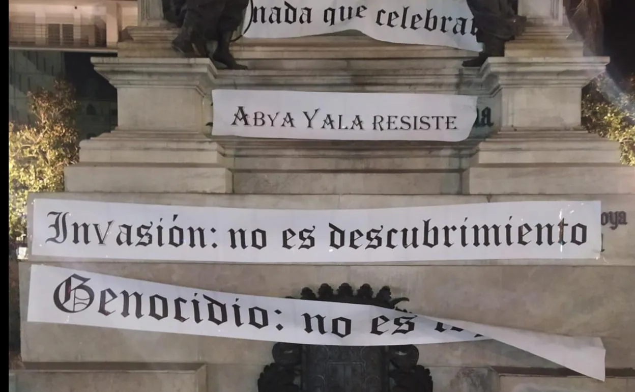 Carteles colocados en la estatua de Isabel la Católica de Granada