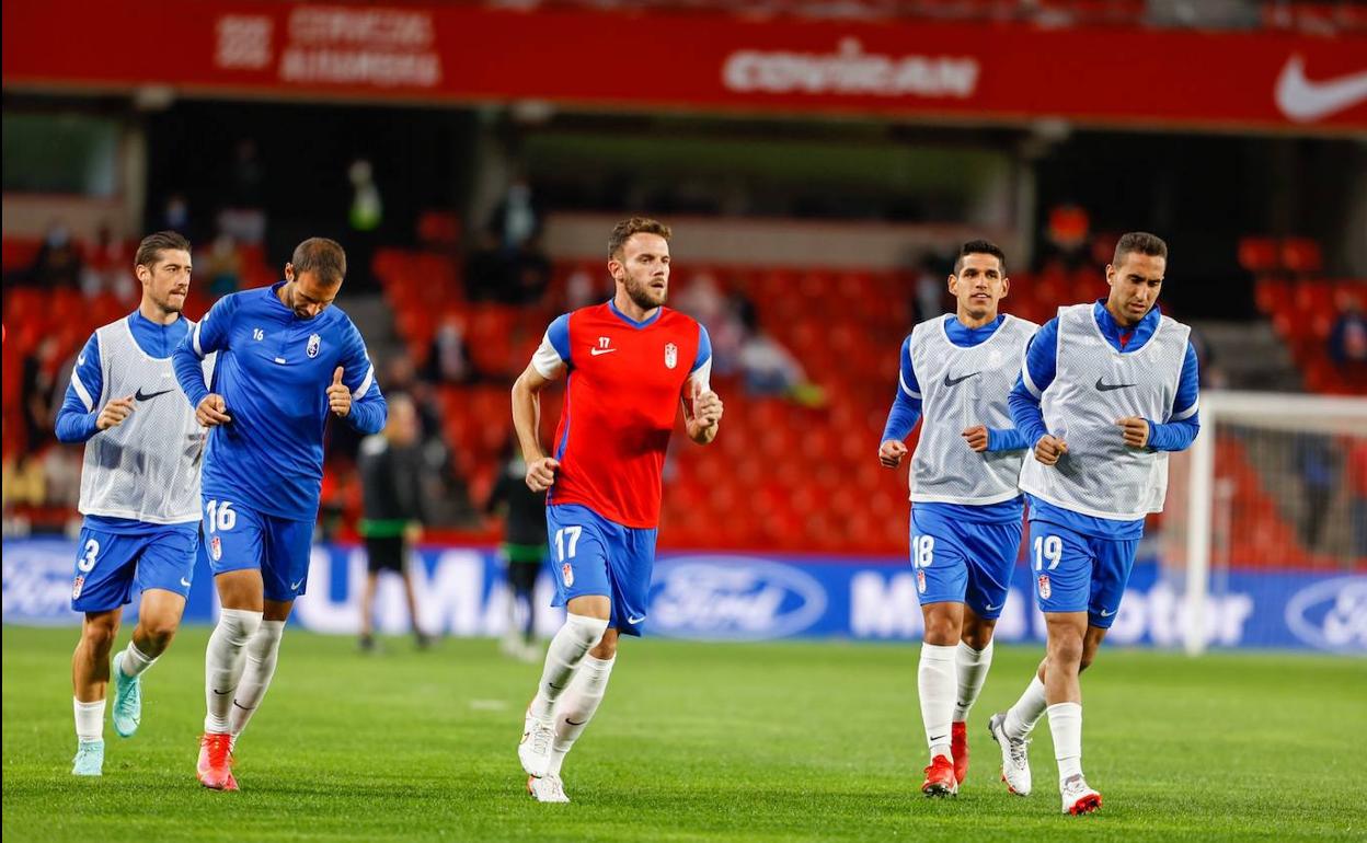 Quini, de rojo, calentando en los minutos previos al Granada-Getafe. 