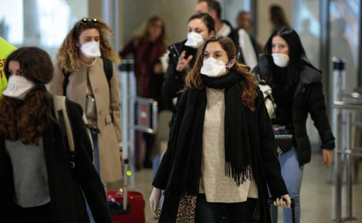 Varias mujeres caminan por un aeropuerto. 