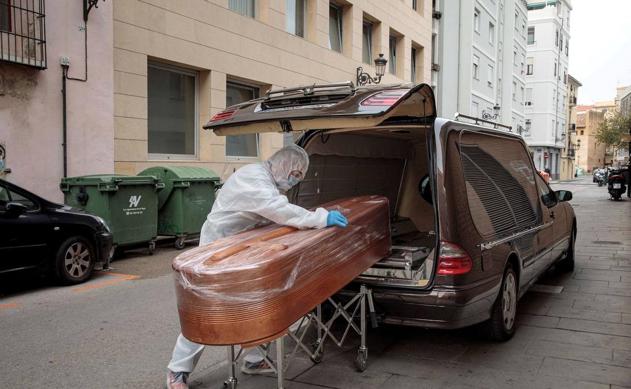 Un empleado de funeraria traslada un cadáver. 