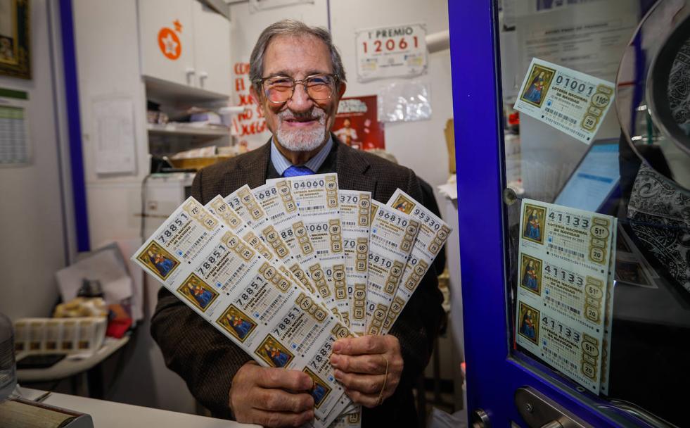 Enrique Requena sostiene los décimos de lotería de Navidad que vende en su administración de la calle Príncipe.