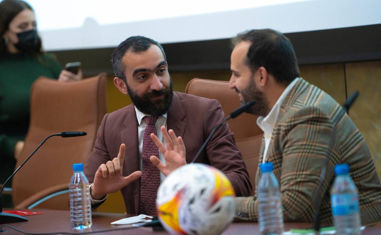 Mohamed El Assy, sonriente, dialoga con César Hernando, con un balón delante. 