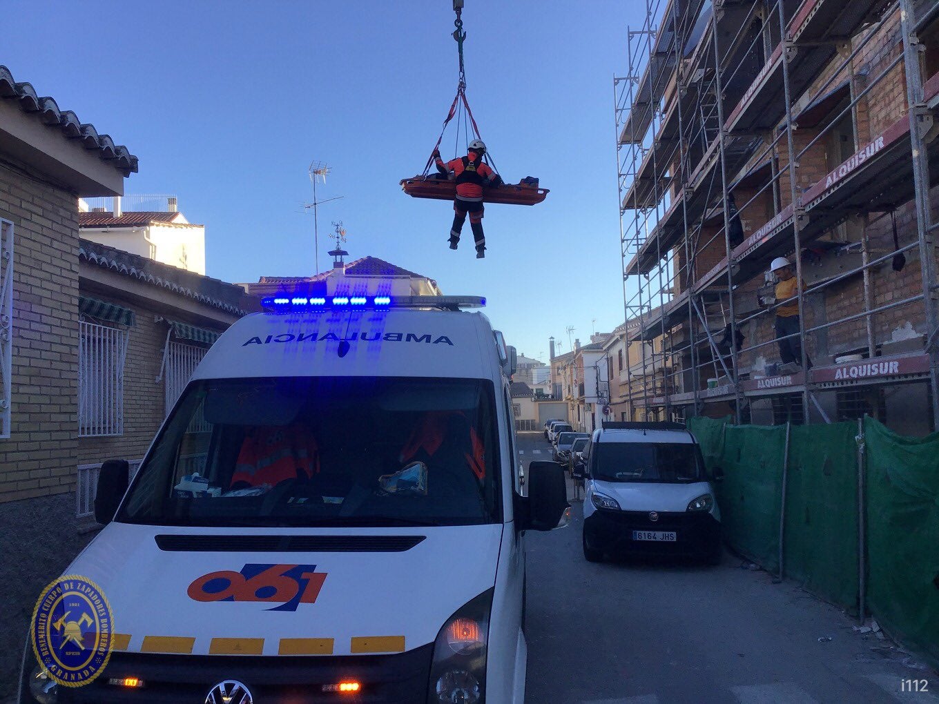 La ambulancia aguarda a que el herido tome tierra para trasladarlo al hospital.