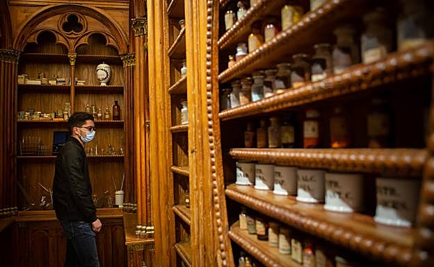 Visitante observa los frascos en la rebotica. 