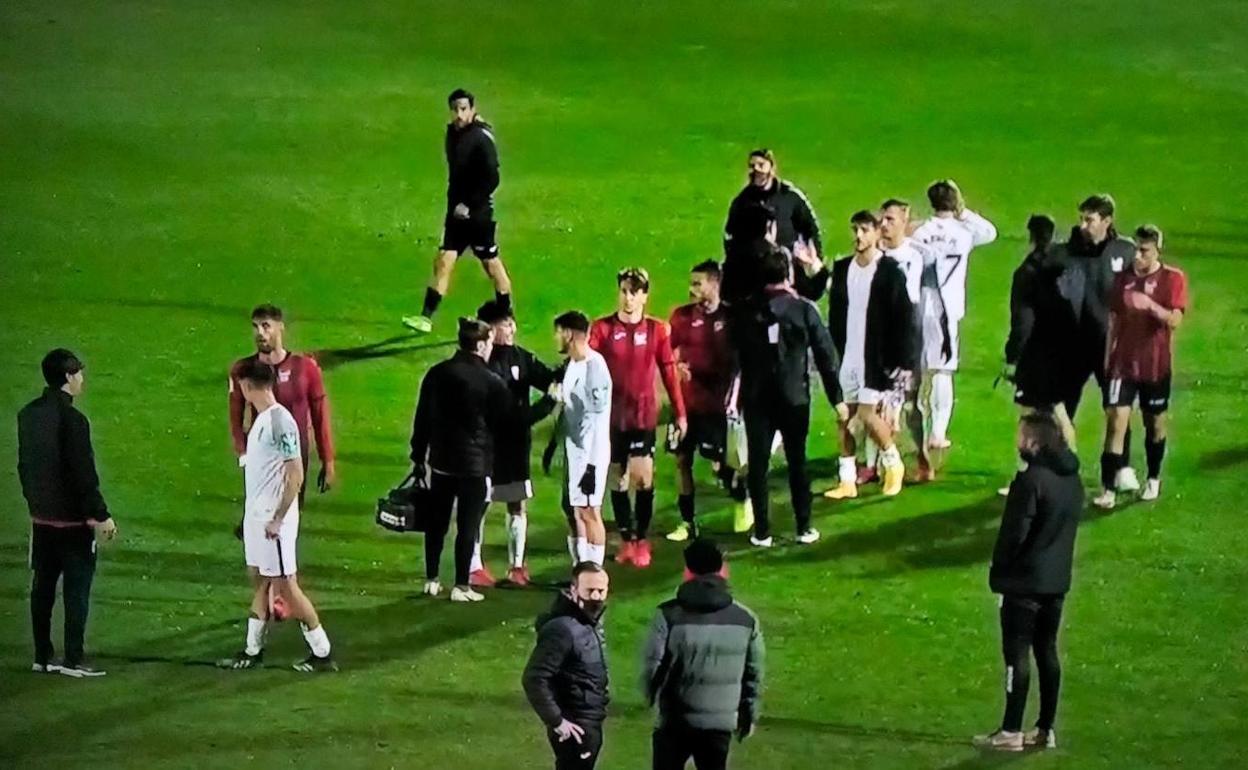 Los jugadores de ambos equipos se saludan al finalizar el partido. 