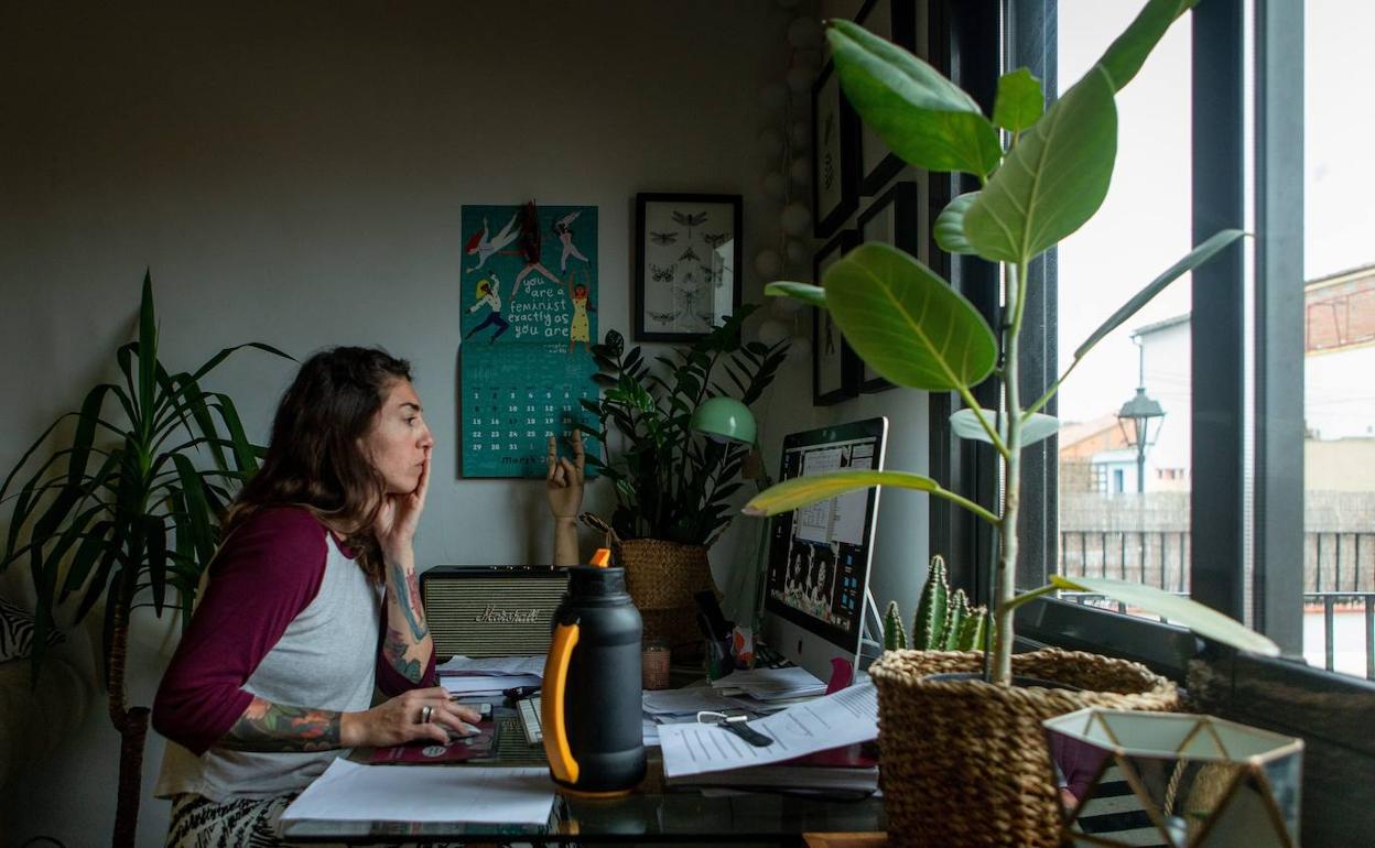 Una mujer realiza teletrabajo en su casa. 