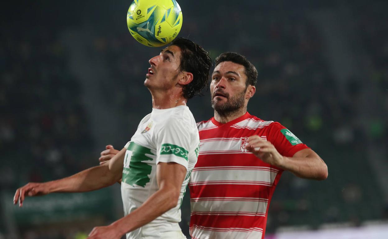 Jorge Molina presiona a Pere Milla, que controla un balón con la cabeza. 