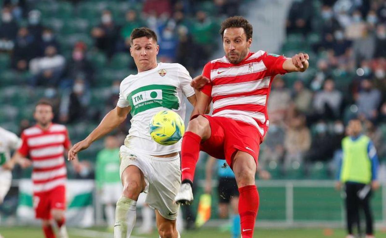Germán intenta despejar el balón ante Guido Carrillo. 
