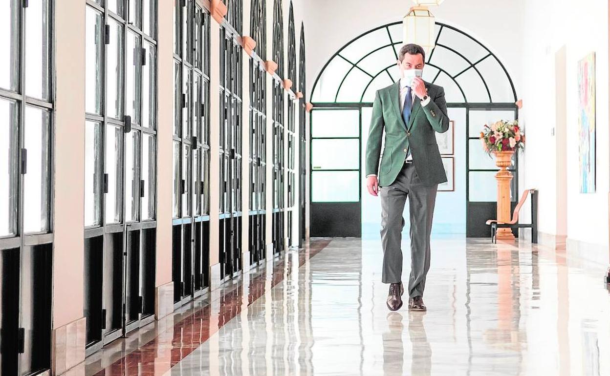 El presidente de la Junta, Juanma Moreno, en los pasillos del Parlamento de Andalucía.