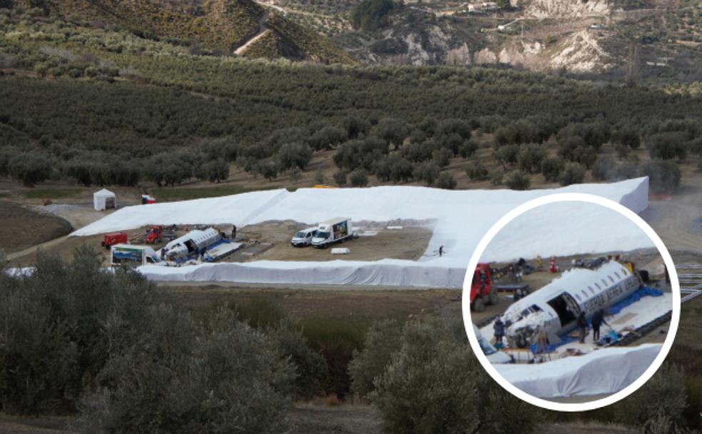 Los restos del fuselaje rodeados de la estructura que cubrirán de nieve artificial, en el cortijo convertido en un auténtico estudio de cine. 