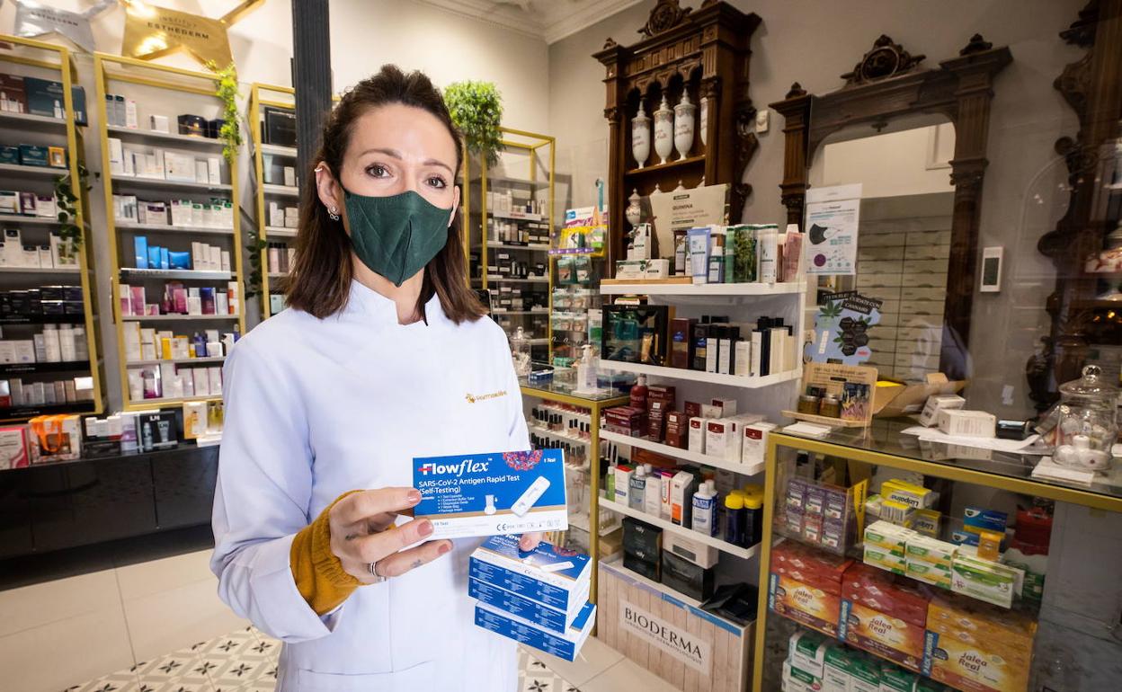 Una farmacéutica muestra varios test en Granada. 