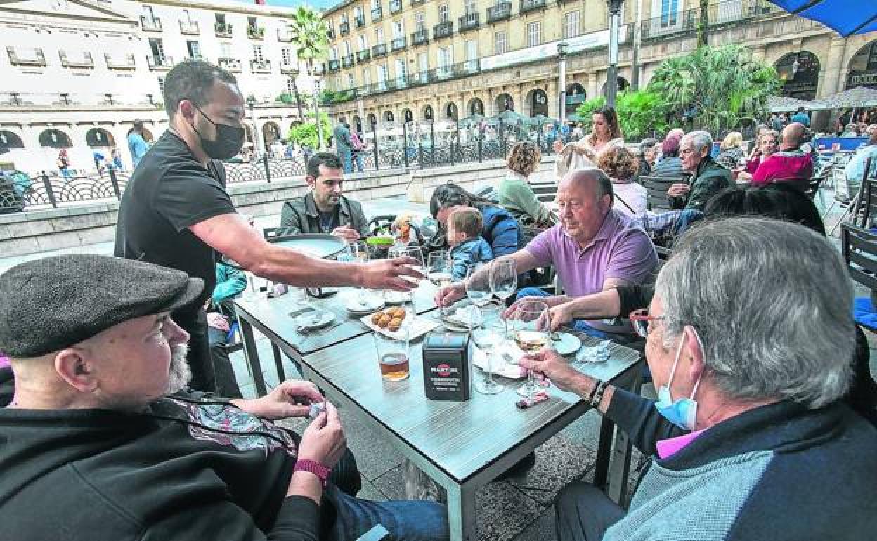 Varias personas, en la terraza de un bar. 