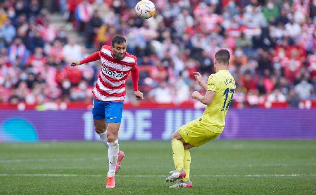Víctor Díaz cabecea un balón ante Lo Celso. 
