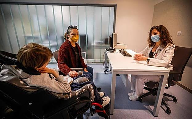 Un paciente con una enfermedad rara pasa consulta junto a su madre. 