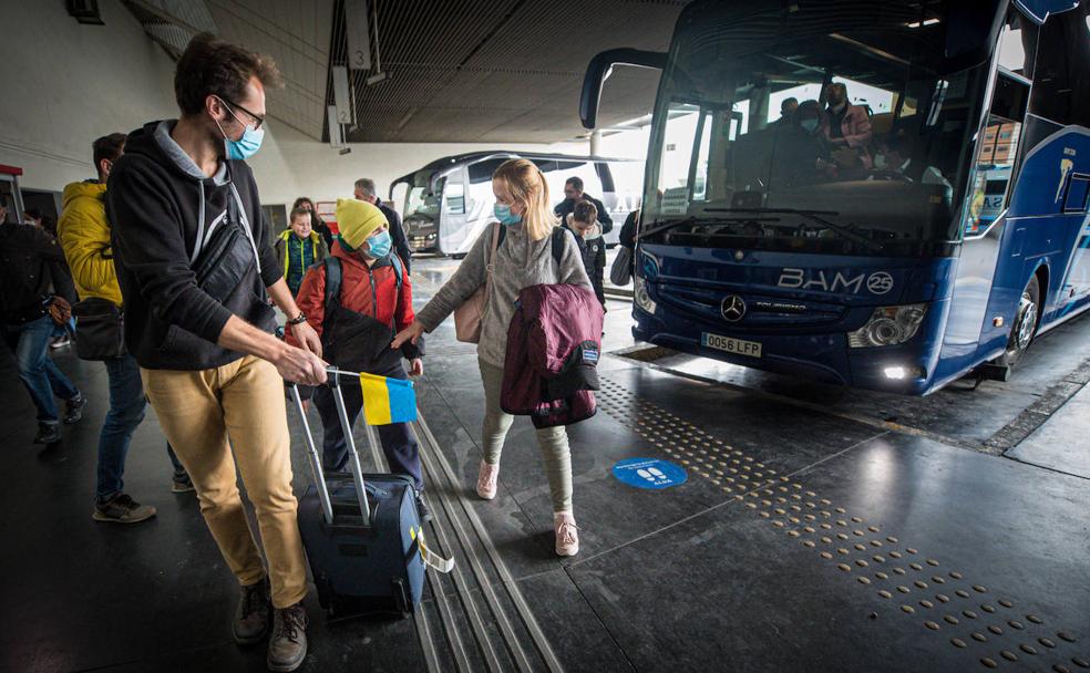 La ucraniana Catherine intenta cogerle la mano a su hijo tras haber llegado a la estación de autobuses de Granada.