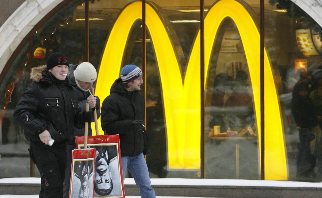 Jóvenes rusos,pasan por delante de un restaurante de McDonald's.,