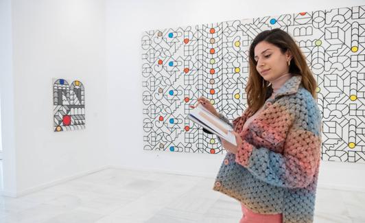 Una visitante observa el catálogo en la exposición.