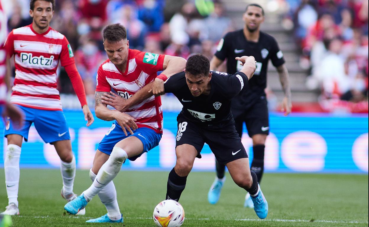 Ponce (derecha) pugna por llevarse un balón con el rojiblanco Petrovic. 