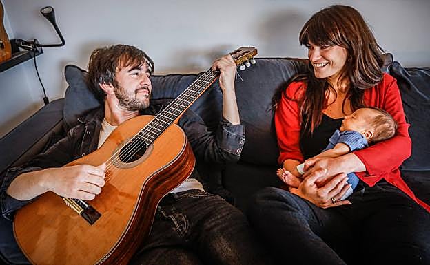 Marco se queda dormido en brazos de su madre mientras su padre toca la guitarra.