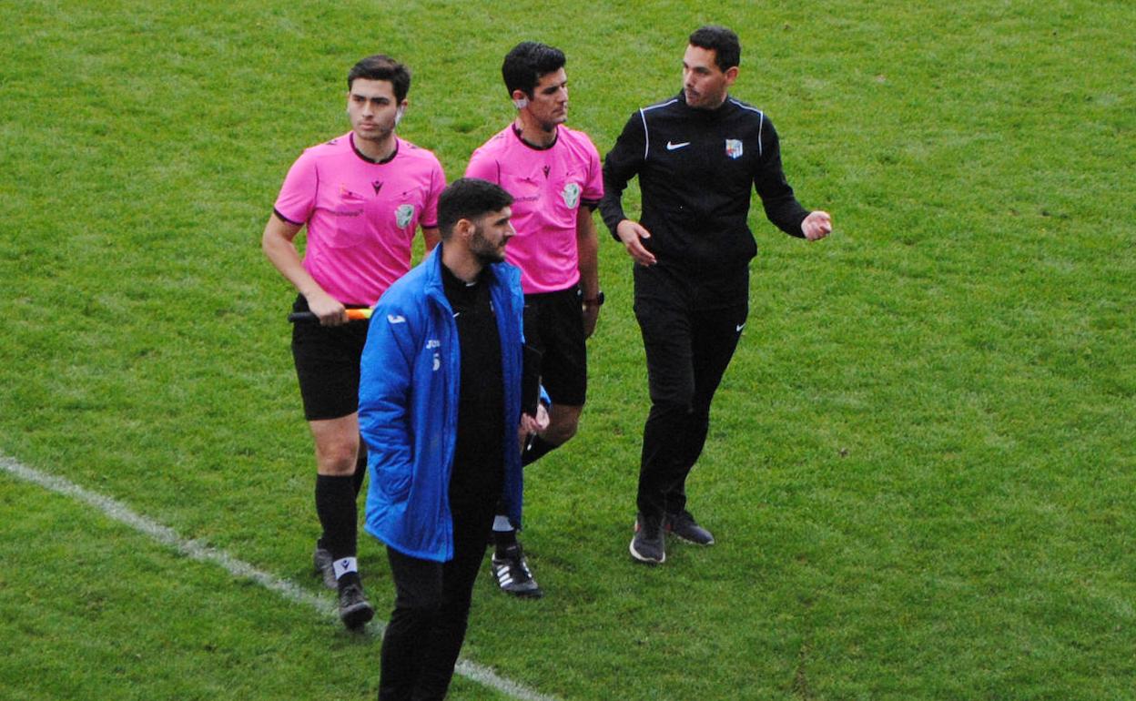 El técnico y el delegado del CF Motril acompañan al colegiado.