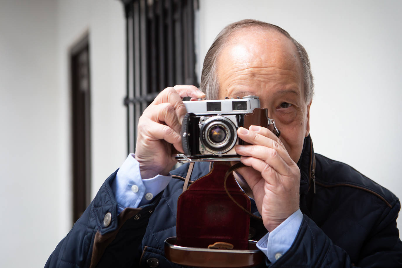 Imagen principal - Pepe Romero con la Kodak que heredó de su padre, su cámara preferida. 