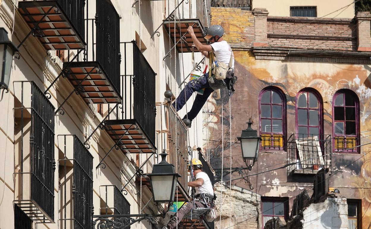 Dos obreros trabajan en la fachada de un edificio en una imagen de archivo. 
