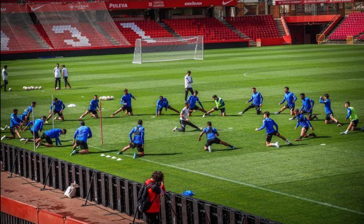 Los futbolistas del Granada estiran en el último entrenamiento previo al partido. 