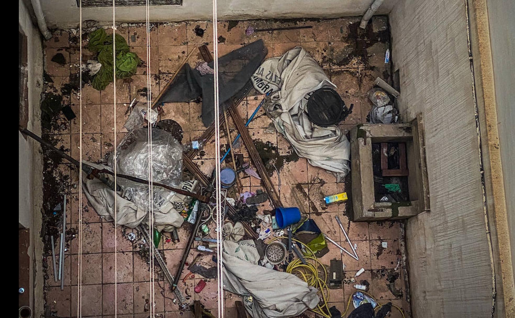 Patio de uno de los bloques con okupas, lleno de basura.