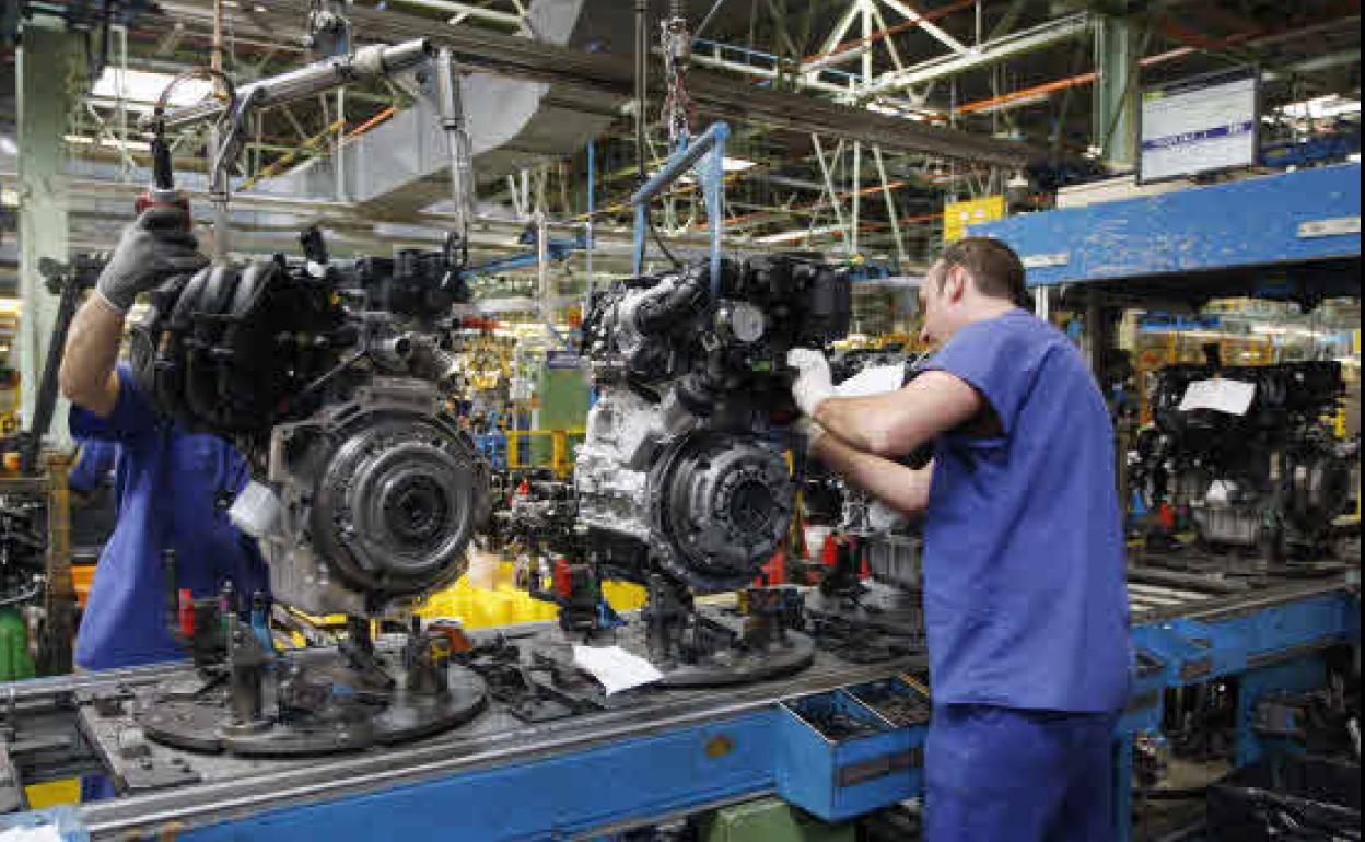 Dos trabajadores, en una fábrica. 