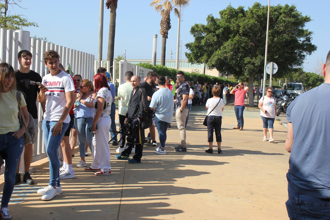 Imagen secundaria 2 - Un aficionado con su camiseta (arriba); varios seguidores, tras pasar el primer filtro, a las puertas de la sede (abajo izda.), la cola 