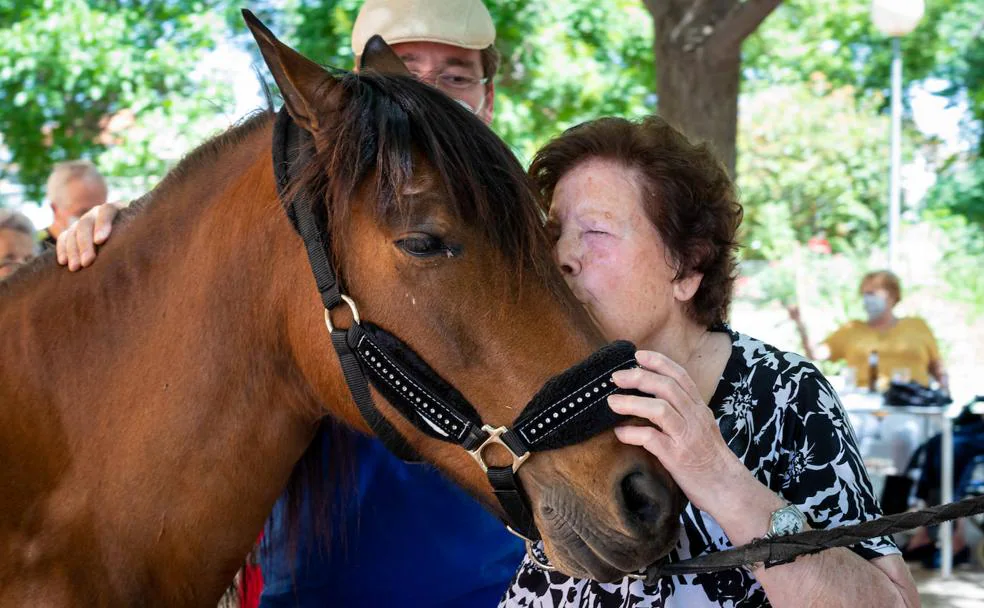 Amelia besa a la yegua Caramela, uno de los equinos con los que interactuaron este jueves los residentes. 