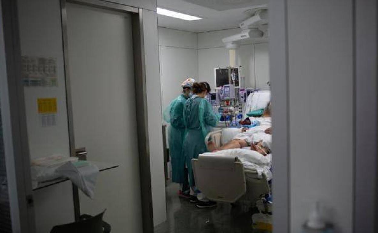 Imagen de archivo de una persona hospitalizada siendo atendida por sanitarios.