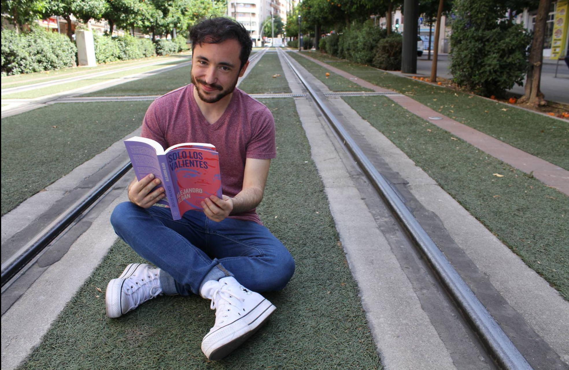 Alejandro Albán, con su libro 'Solo los valientes', en las vías del metro de Granada. 