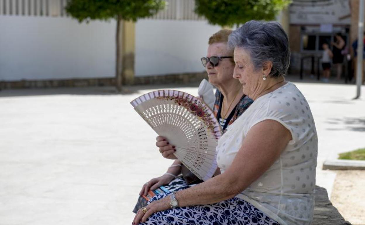 Dos mujeres buscan alivio del calor en el parque de La Alameda, este domingo. 