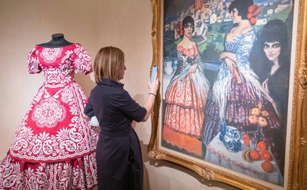 Observando uno de los cuadros que conforman la exposición. 