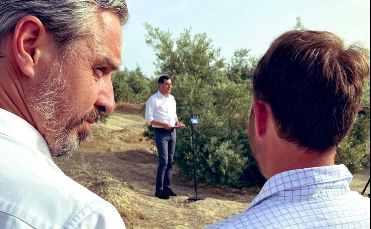 Juan Bravo y Erik Domínguez, del PP, escuchan a Juanma Moreno en Torredelcampo al final de la campaña. 