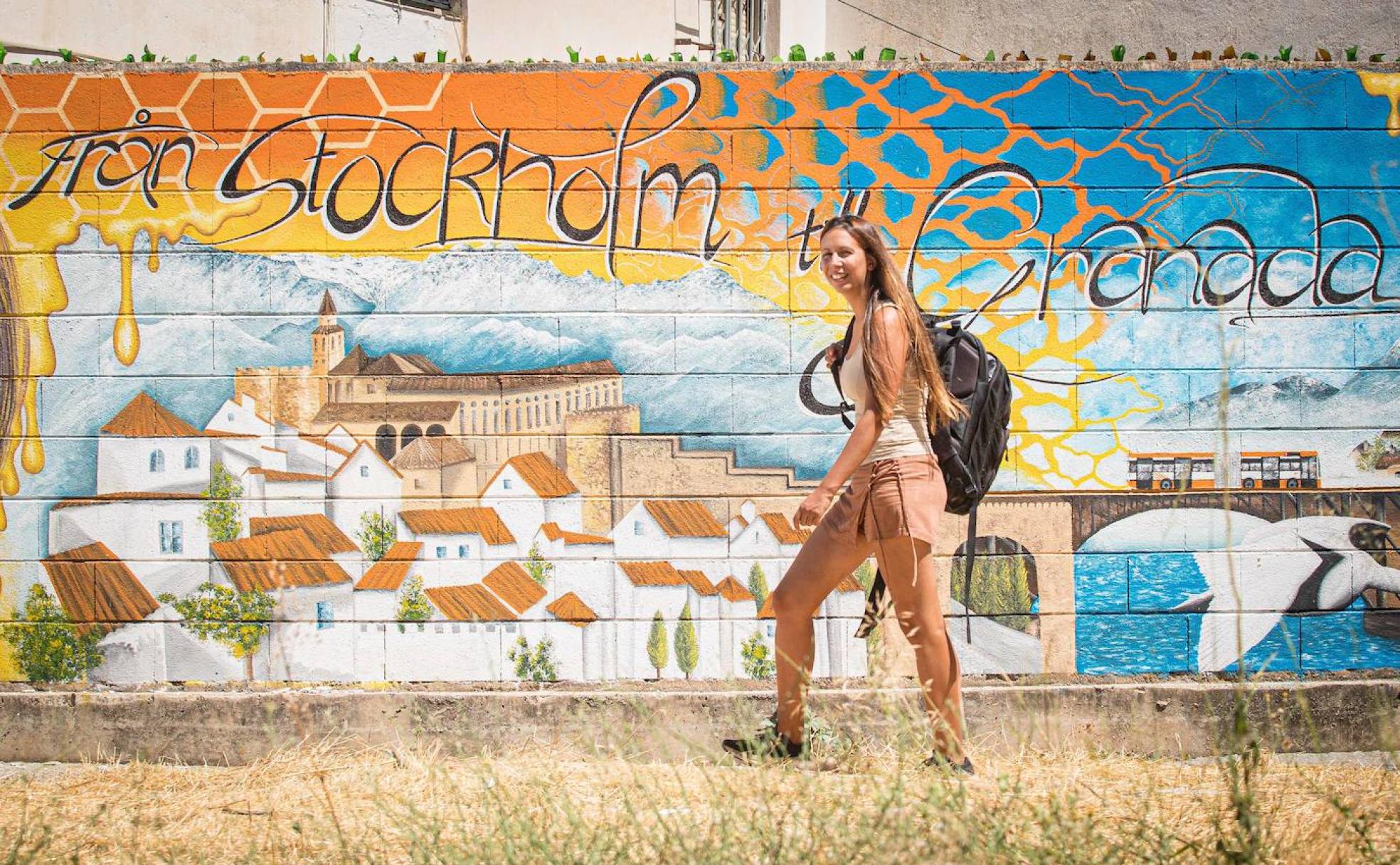 Alisa Host camina por el mural que ha pintado en el Paseo de Cartuja. 