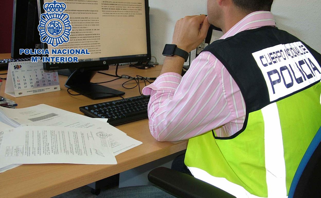 Un agente de la Policía Nacional experto en extranjería examina documentos.