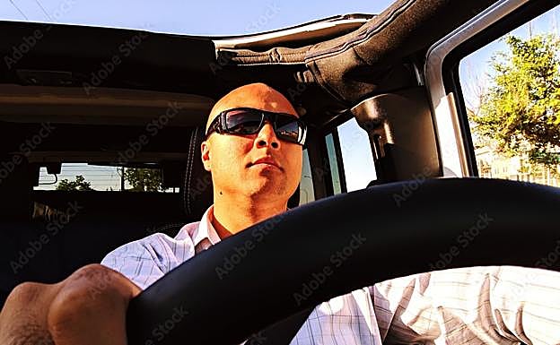 Un hombre conduce con las gafas de sol puestas