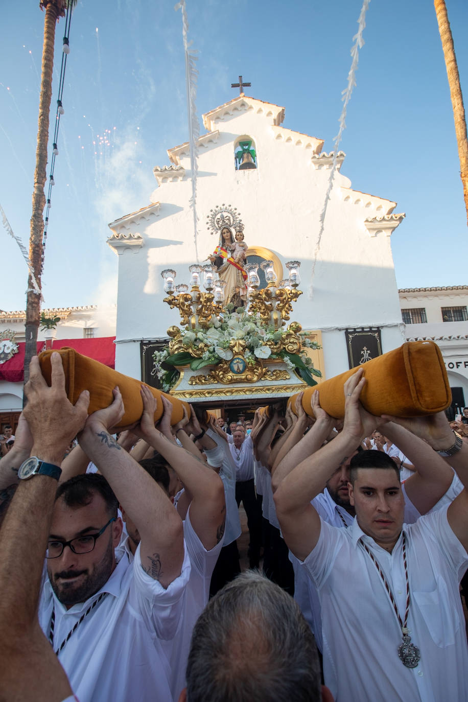 El trono de la Virgen del Carmen recibe una petalá a su paso por una de las calles de Varadero en Motril.