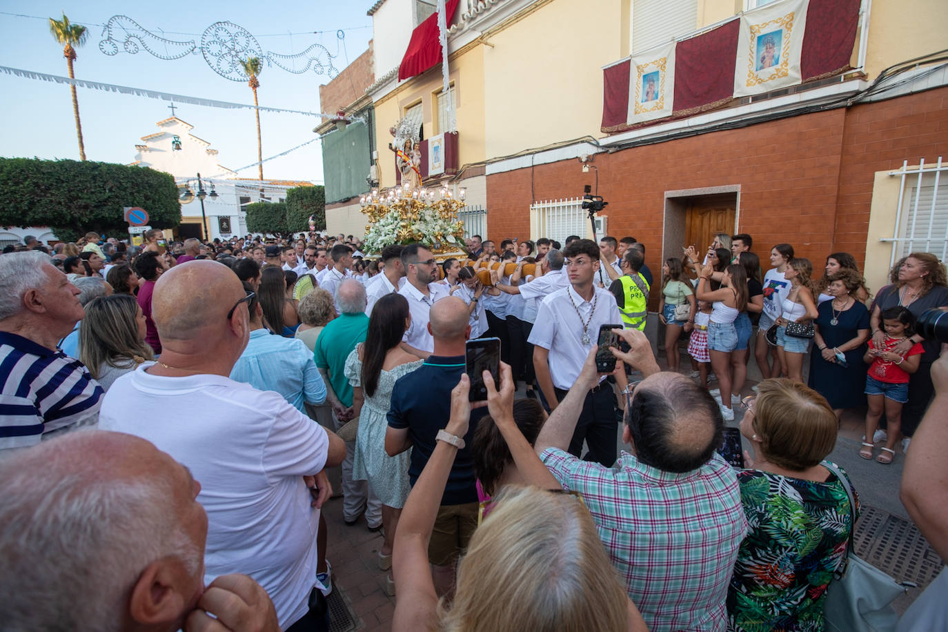 El trono de la Virgen del Carmen recibe una petalá a su paso por una de las calles de Varadero en Motril.