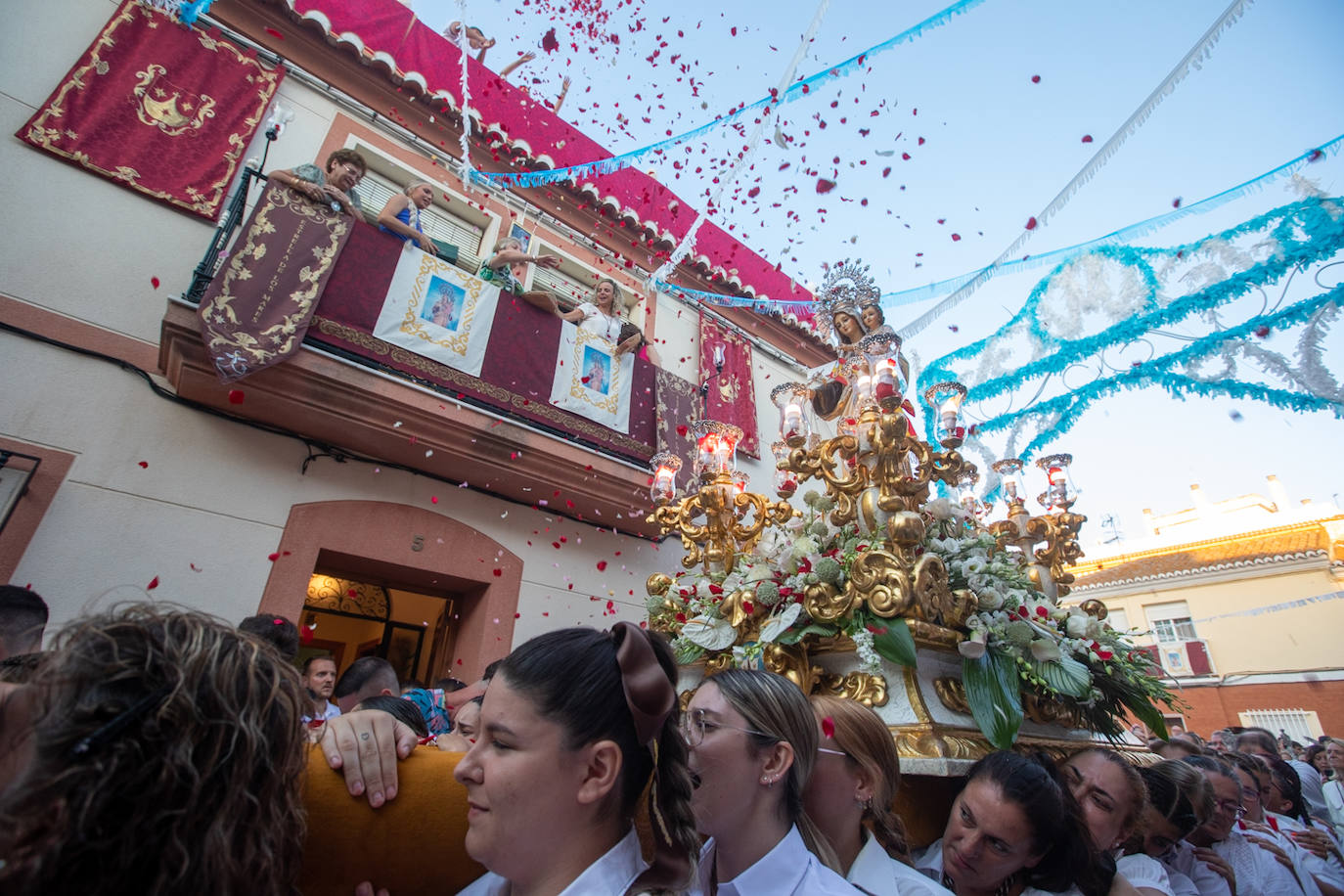 El trono de la Virgen del Carmen recibe una petalá a su paso por una de las calles de Varadero en Motril.