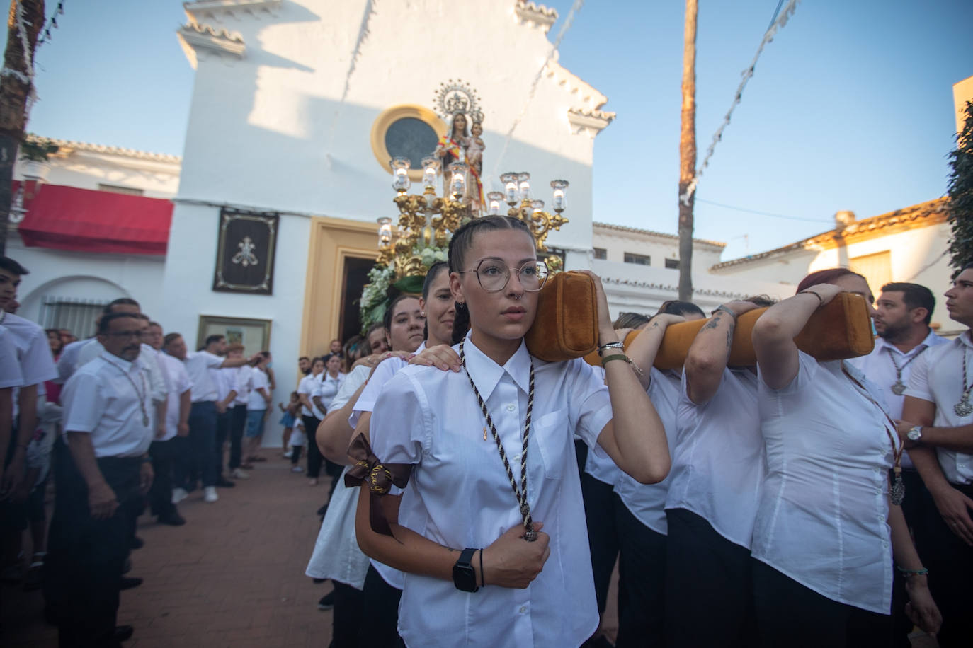 El trono de la Virgen del Carmen recibe una petalá a su paso por una de las calles de Varadero en Motril.